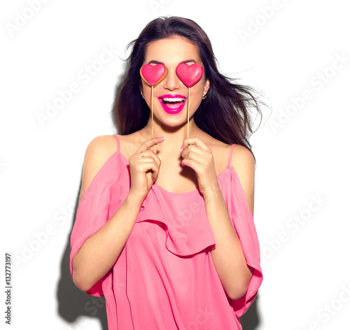 Valentines Day. Beauty joyful young fashion model girl with Valentine Heart shaped cookies in her hands