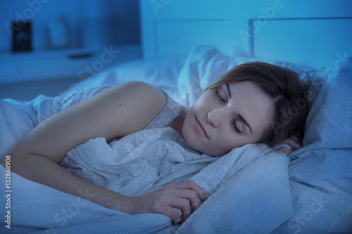 Girl peacefully sleeping in bed at night