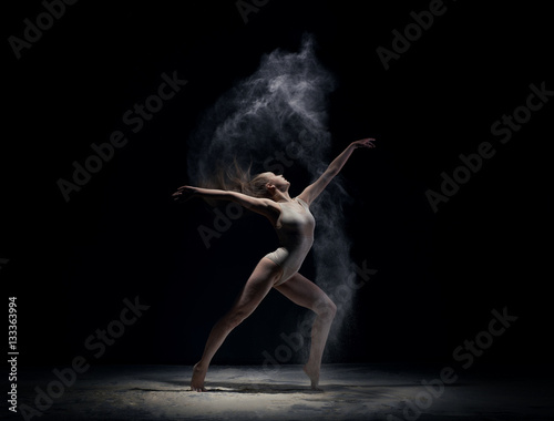 Obraz na płótnie Athletic dancer in cloud of powder on the scene