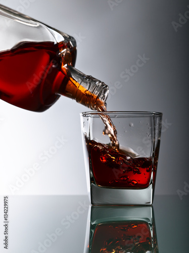 bottle and glass of whiskey on a glass table