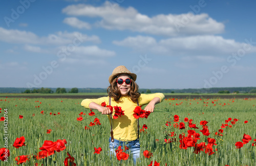 happy little girl on poppies flower field
