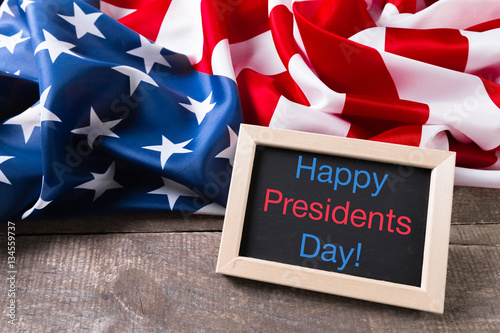 Poster the text happy presidents day written in a chalkboard and a flag of the United S