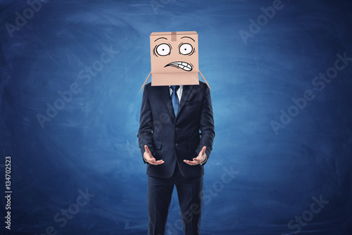 Poster Businessman is wearing cardboard box with drawn shocked face on his head