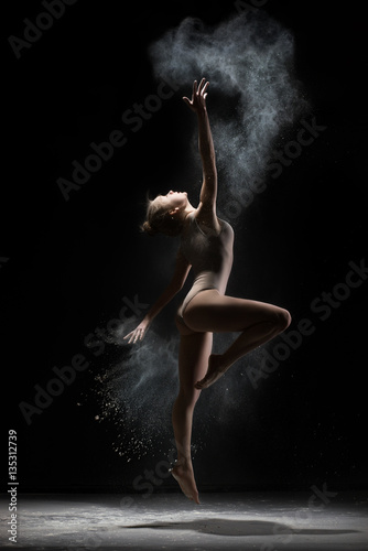 Obraz na płótnie Female gymnast dances in cloud of white powder