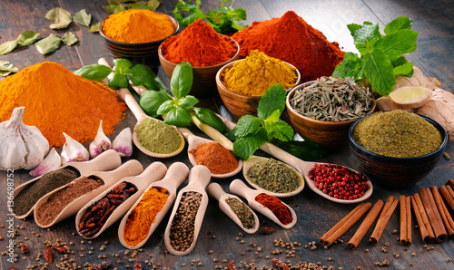 Variety of spices and herbs on kitchen table © monticellllo