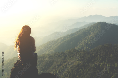silhouette woman sitting on mountain in morning and vintage filter © nakedcm