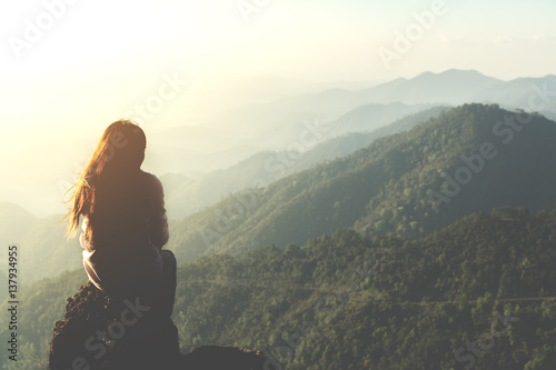 Valokuva silhouette woman sitting on mountain in morning and vintage filter