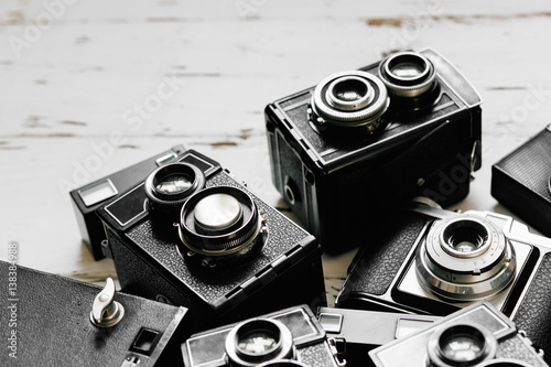 old vintage retro photo cameras on white wooden background
