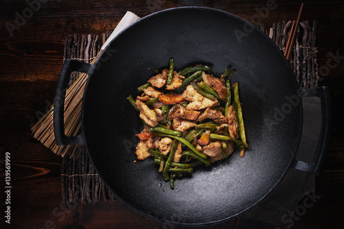 stir fried chicken in cast iron wok in flat lay composition