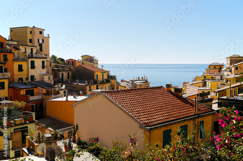 Poster One of Cinque Terre villages, Riomaggiore, with blue sea and sky in the background