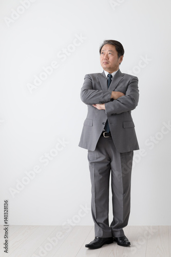 腕組みをするビジネスマン、中年男性