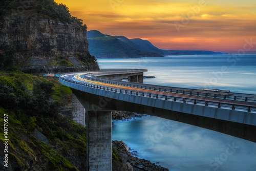 Poster Sunset over the Sea cliff bridge along Australian Pacific ocean coast with light