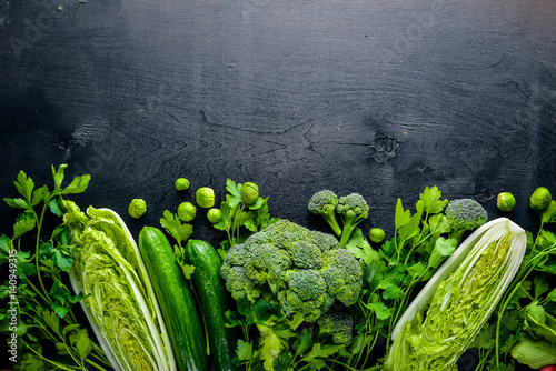 Poster Collection of fresh green vegetables placed on black stone