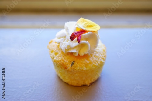 Poster Mini lemon rosemary cupcake with edible flower petals and white buttercream fros