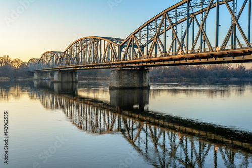 Obraz na płótnie Jozef Pilsudski road bridge reflected in Vistula river in the morning. Torun, Poland. Europe.