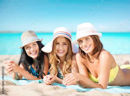 happy young women in bikinis on summer beach