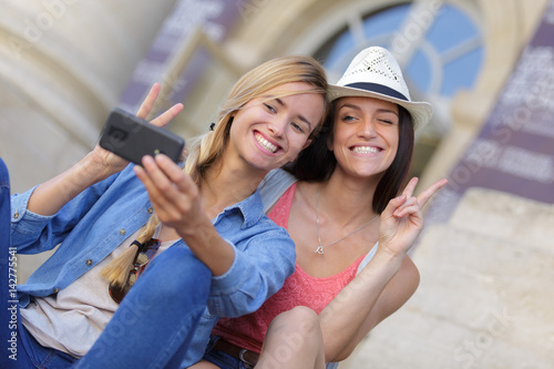 Billede cheerful tourist female friends taking photos of themselves
