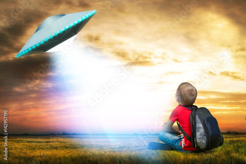 Poster The little boy looks up at an unidentified flying object which appeared in the sky