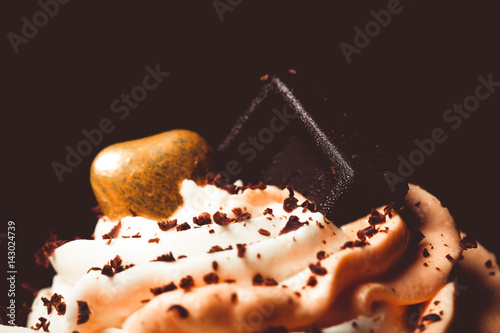 Poster Vanilla cupcakes with orange and white creamcheese and chocolate decor