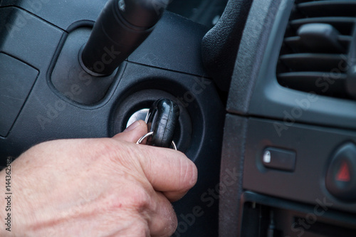 Poster The driver is about to start the car, holds the key in his hand who is in the lo