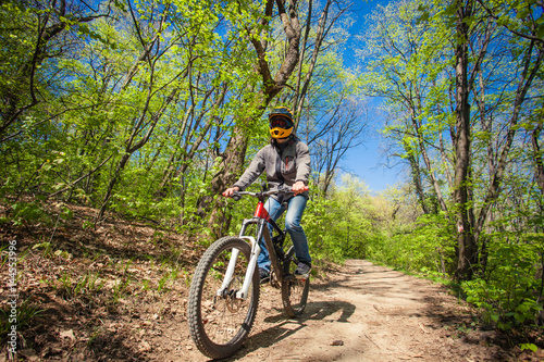 man ride mountain bike through forest