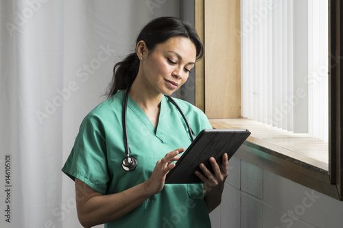 Nurse looking at her tablet © Burlingham