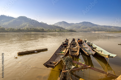 Traditional old wooden fishing boat floating on Mekong river in North Thailand, outdoor day light