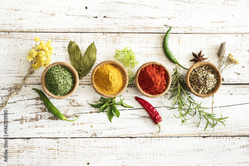 Spices and herbs on wooden background © sebra