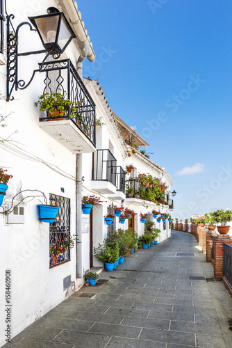Lacobel Walkway with flower pots on the wall in the white village of Mijas, Costa del Sol, Andalusia, Spain