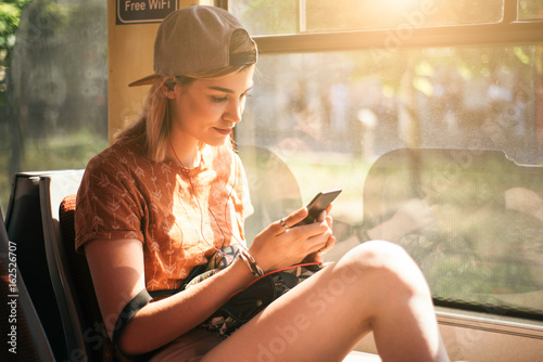 Young teenage girl using her cell phone in public transportation © Astarot