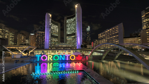Toronto City Hall and Toronto sign in Nathan Phillips Square at night, Ontario, Canada.