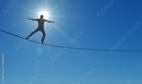 Highline walker over blue sky background