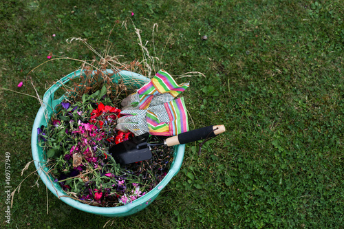 A Green Plastic Garden Basket With Waste Trowel And Gloves A Green Plastic Garden Basket With Waste Trowel And Gloves