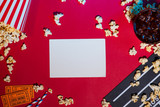 Cinema concept. Clapperboard, ticket and popcorn on red background