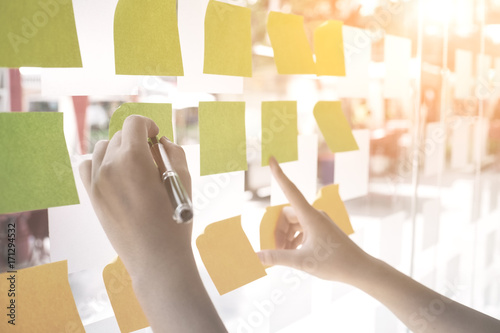 Hands using post it paper note to memo or share ideas.