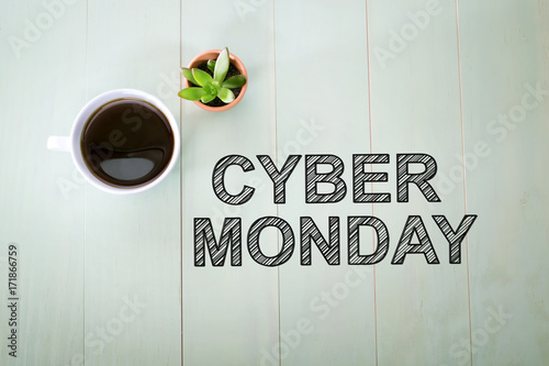 Cyber Monday text with a cup of coffee on a pastel green wooden table