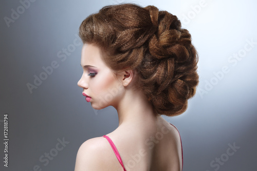 Beauty portrait of a young beautiful girl with a voluminous hair on a gray background. © ksi