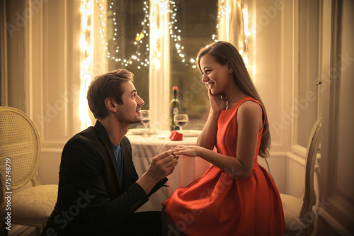 Handsome man proposing a beautiful woman to marry him in an elegant restaurant © merla