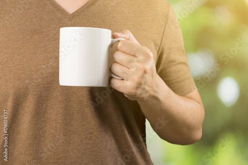 Asian man on Brown t-shirt Holding coffee cup .Relaxing ,feel good