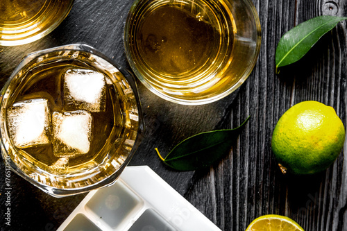 glass of scotch on dark wooden background top view