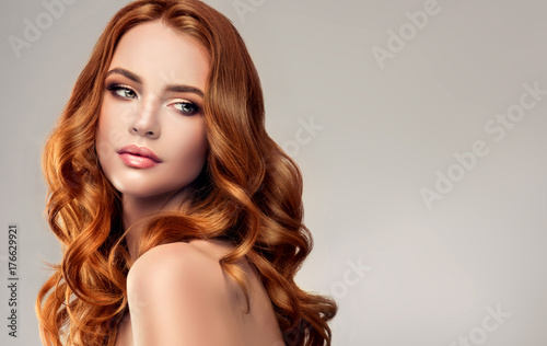 Beautiful model girl with long red curly hair .Red head . Care and beauty hair products © edwardderule