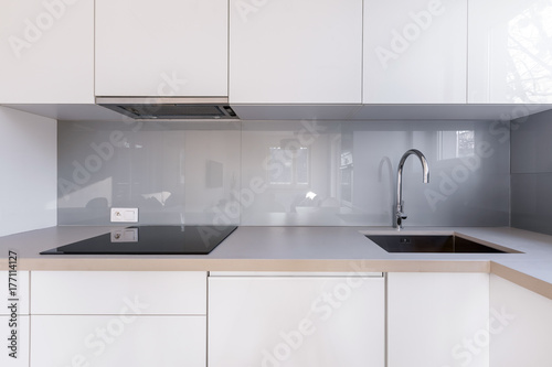 Fototapeta White kitchen with gray backsplash