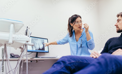 Dentist showing x-ray to a patient