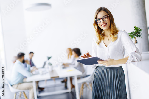 Elegant businesswoman standing in office with digital tablet © Boggy