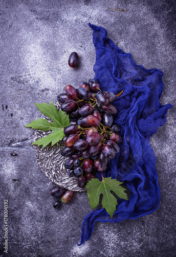 Bunch of purple grapes on concrete background