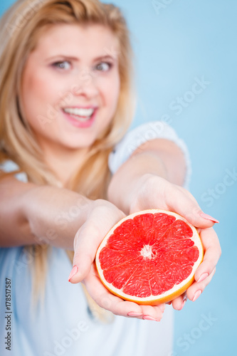 Woman holds grapefruit citrus fruit in hands
