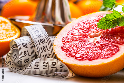 Measure tape and fresh citrus fruit orange lemon tangerine lime lemon and grapefruit.