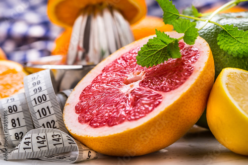 Measure tape and fresh citrus fruit orange lemon tangerine lime lemon and grapefruit.