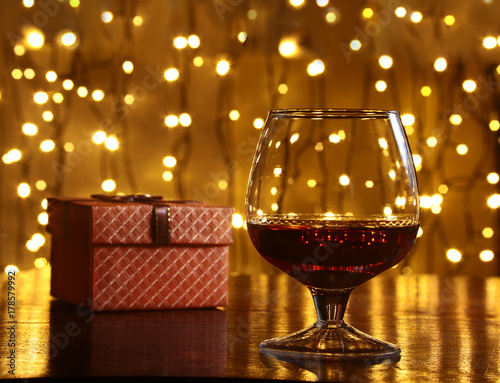 Whiskey, cognac, brandy and gift box on wooden table. Celebration composition on the light background.
