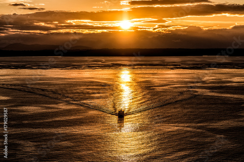 Sunset Over Water Boat in Sunlights Reflection in Gold Color
